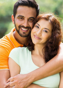 young couple in orange and white | Dental Care Studios