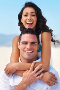 young couple in white smiling | Cosmetic Dentistry