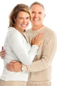 older couple holding each other and smiling | Dentures
